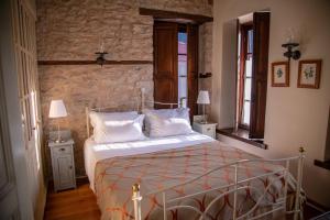 a bedroom with a bed and two tables and two windows at Epoches Luxury Suites in Karpenision