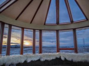 a room with a view of the ocean through windows at Klettar Tower Iceland in Fludir