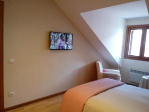 a bedroom with a bed and a tv on the wall at Apartamento Broto in Broto