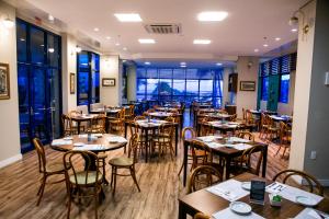 a restaurant with tables and chairs in a room at Hotel Bhally in Balneário Camboriú