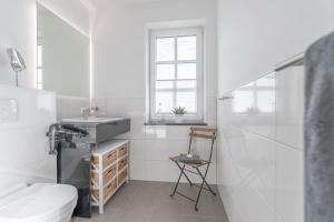 a white bathroom with a sink and a toilet at Haus Seegras in Börgerende-Rethwisch