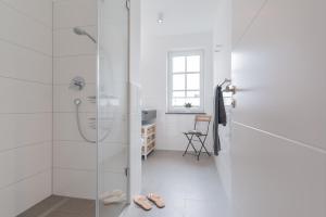 ベルガーエンデ・レートヴィッシュにあるHaus Seegrasの白いバスルーム(シャワー、靴付)