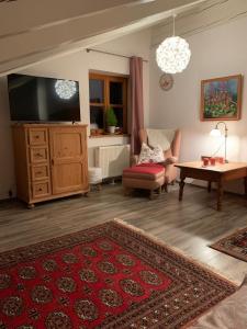 sala de estar con TV, sofá y mesa en Entspannen mit Bergpanorama, en Siegsdorf