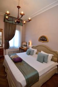 une chambre avec un grand lit blanc avec un lustre dans l'établissement B&B Villa Ines, sur le Lido de Venise
