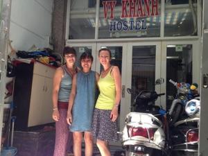 three women posing for a picture in front of a motorcycle at Vy Khanh Guesthouse in Ho Chi Minh City