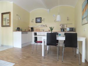 uma cozinha com uma mesa branca e cadeiras pretas em Villa Jordan em Radebeul
