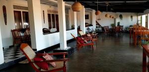 a restaurant with chairs and tables and a room with tables and chairs at Sea Shine Guest House in Hikkaduwa