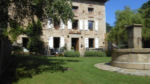 a stone house with a fountain in the yard at Domaine de Sault in Dore-lʼÉglise