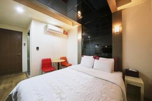 ソウルにあるK2 Motelのベッドルーム1室(ベッド1台、赤い椅子2脚付)
