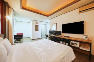 um quarto de hotel com uma cama e uma televisão de ecrã plano em K2 Motel em Seul