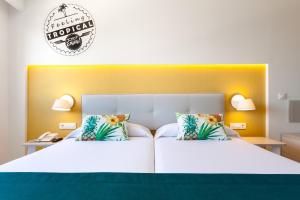
a hotel room with two beds and two lamps at Hotel Tropical Park in Callao Salvaje
