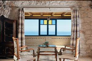um quarto com duas cadeiras, uma mesa e uma janela em Diamond Suites em Vasilikos