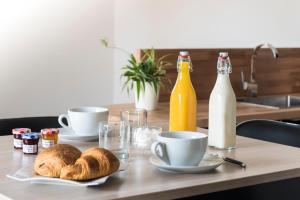 a table with two plates of bread and bottles of milk at Gîte de la Daudière La Grange in Le Boupère