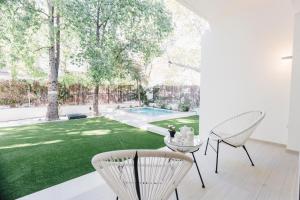 un patio con 2 sillas, una mesa y un patio en Minty Stay - Palmera, en Sevilla