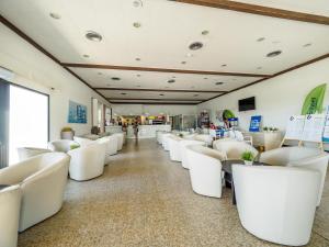 a row of white chairs in a waiting room at I Giardini di Athena- Athena Resort in Scoglitti