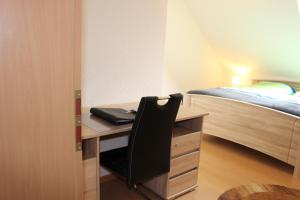 een slaapkamer met een bureau en een bed met een bed gmaxwell gmaxwell gmaxwell gmaxwell bij Ferienwohnung Vier Sterne in Goslar