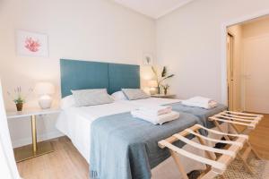 1 dormitorio con 1 cama con cabecero azul y escritorio en Minty Stay - Palmera, en Sevilla 65 fotos más