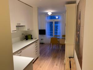 a kitchen with white cabinets and a dining room at Kangaroom in Amsterdam