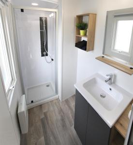 un baño con lavabo y ducha en Camping Officiel Siblu Domaine de Dugny, en Onzain