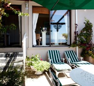 a patio with two chairs and a table and an umbrella at 123 Ocean View Drive Apartment in Cape Town