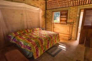 a bedroom with a bed in a room with a window at ATTA Rainforest Lodge in Surumatra