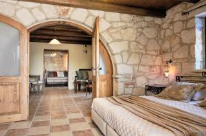 a bedroom with a bed in a stone wall at Diamond Suites in Vasilikos