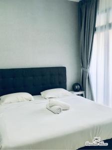 a bed with two pillows on it in a bedroom at City Life by J&G Vacation Homes in Skudai +17 photos