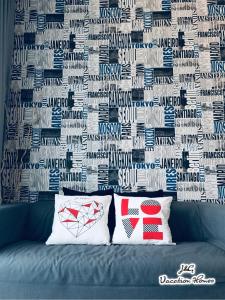 a couch with two pillows in front of a wall at City Life by J&G Vacation Homes in Skudai