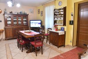 a dining room with a table and chairs and a television at B&B Mitzixeddas in Màndas
