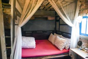 uma cama vermelha num quarto com cortinas em Shabby Home 28 em Jiufen