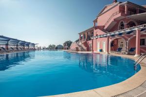 a large swimming pool in front of a building at Hotel Elena Ermones in Ermones