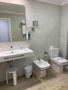 a bathroom with a sink and a toilet and a mirror at Hotel Puerta del Mar - Adults Recommended in Nerja