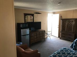 a living room with a refrigerator and a television at Riviera Motor Lodge in Myrtle Beach