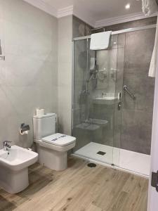 a bathroom with a shower and a toilet and a sink at Hotel Puerta del Mar - Adults Recommended in Nerja