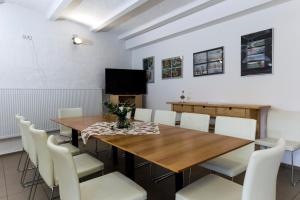 a dining room with a wooden table and white chairs at Havelhöfe Garz in Garz