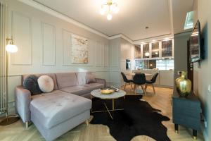 a living room with a couch and a table at Mennica Central Apartments in Warsaw