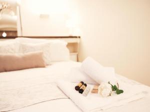 ein weißes Bett mit zwei Flaschen Wein und Blumen in der Unterkunft Suite San Domenico in Turin
