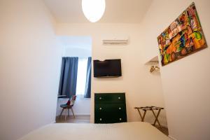 ein Schlafzimmer mit einem Bett und einem TV an der Wand in der Unterkunft Stella del Mattino in Salerno