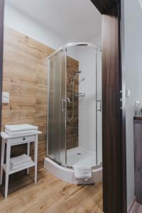 a shower stall in a bathroom with a table at Hotel Majerzanka in Piwniczna-Zdrój