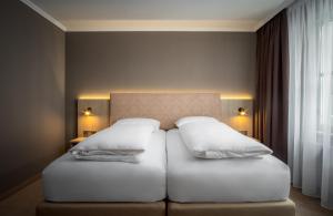 a hotel room with two beds and two lamps at AWA Hotel in Munich