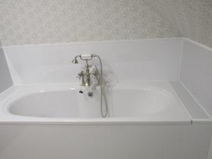 a bath tub with a faucet in a bathroom at Lindfields in Inverness +18 photos