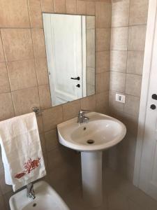 a bathroom with a sink and a mirror and a toilet at Cielo e mare in Golfo Aranci