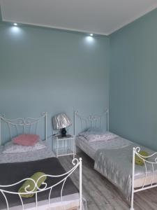 two beds in a room with blue walls at Apartament Dworcowa in Chełmno