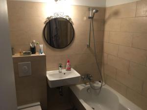 a bathroom with a sink and a tub and a mirror at Cosy flat in trendy Sprengelkiez (legal) in Berlin