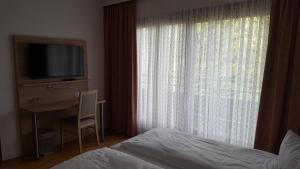 a bedroom with a television and a bed at ITM Hotel Deutsches Haus in Hamburg