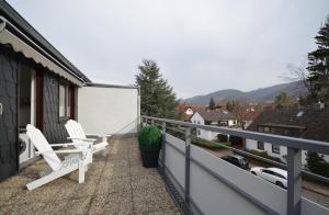 een balkon met twee witte stoelen op een huis bij Harz-Liebe Penthouse in Bad Harzburg