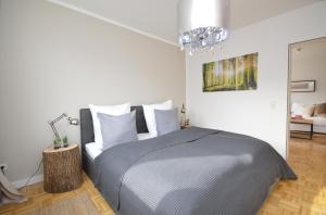 een slaapkamer met een bed en een kroonluchter bij Harz-Liebe Penthouse in Bad Harzburg