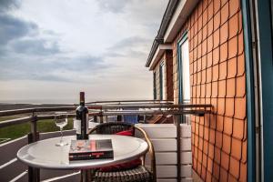 einen Tisch mit einem Glas Wein auf dem Balkon in der Unterkunft Dünenglück, Ferienwohnung 33 in Cuxhaven