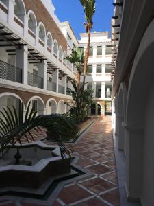 a courtyard of a building with a palm tree at Avda de las Palmeras Apartment in Benalmádena
