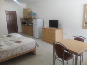 a bedroom with a bed and a table and a refrigerator at Cypress Tree Apartments in Bethlehem